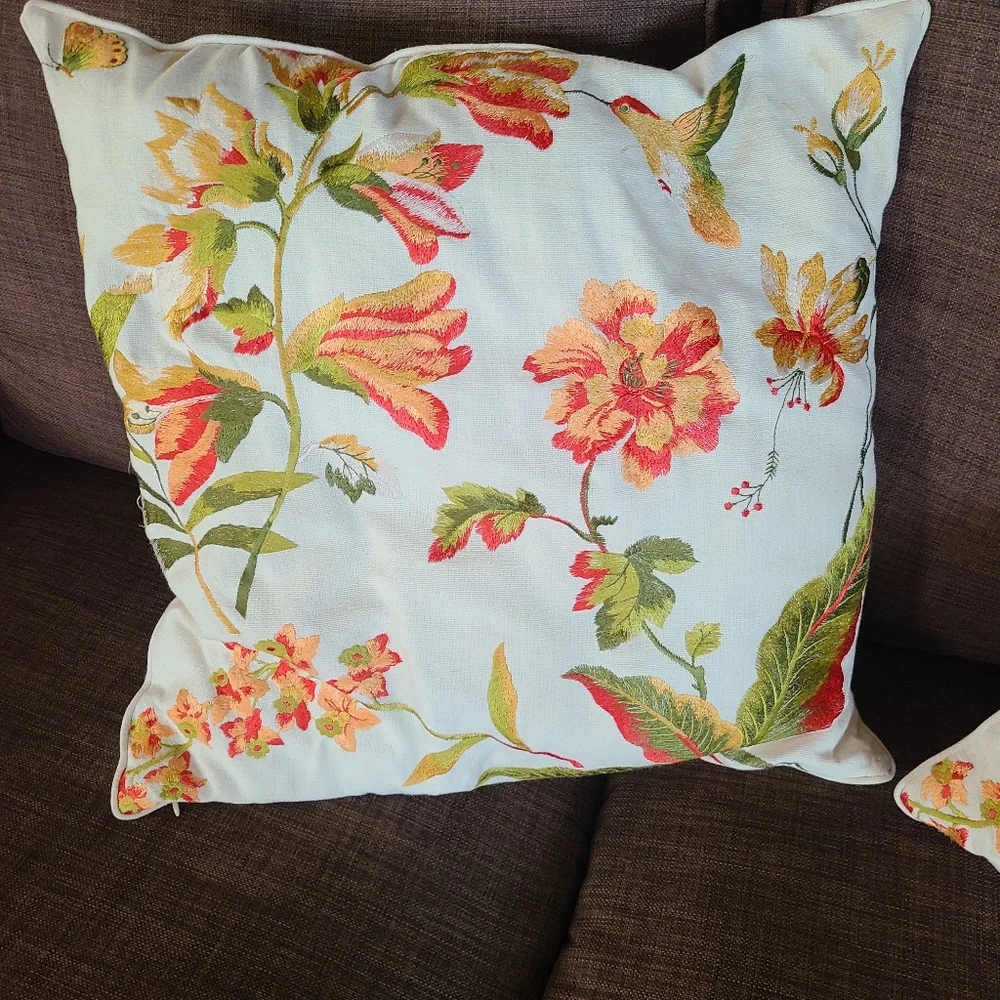2 pillows with embroidered flowers and hummingbirds
